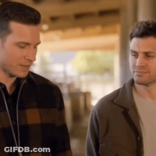 Two Men Standing And Talking In Room GIF