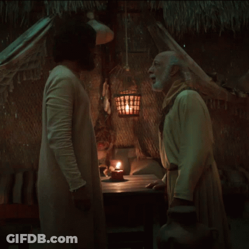 Two Men Standing Beside Candle In Dark Room GIF