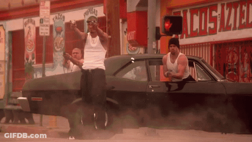 Two Men Standing By Car In Front Of Cosmo Store GIF