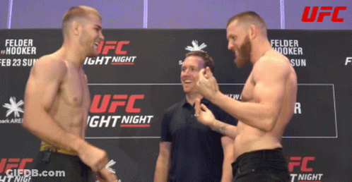 Two Men Standing By UFC Light Night Sign GIF