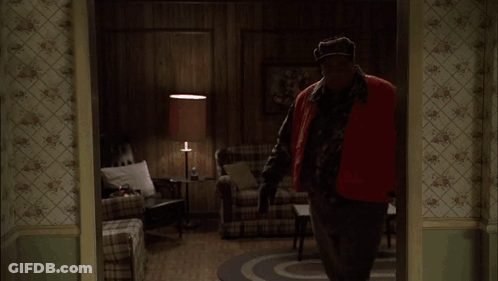 Two Men Standing In A Kitchen With A Bottle Of Liquor On The Counter GIF