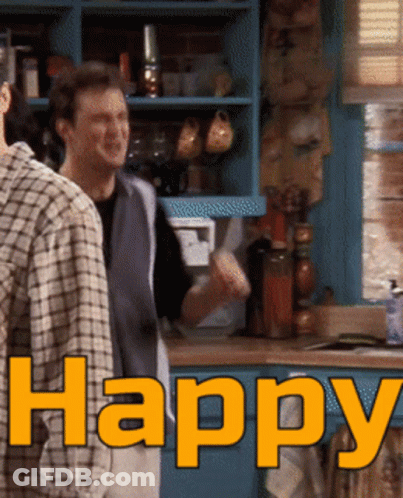 Two Men Standing In A Kitchen With The Word Happy Written In Orange GIF