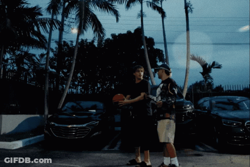 Two Men Standing In A Parking Lot Holding A Basketball GIF