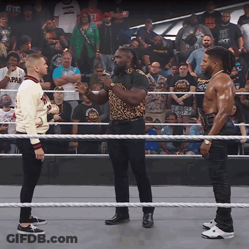 Two Men Standing In A Wrestling Ring With One Wearing A Sweater That Says Japan GIF