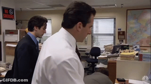 Two Men Standing In An Office With A No Smoking Sign On The Wall GIF