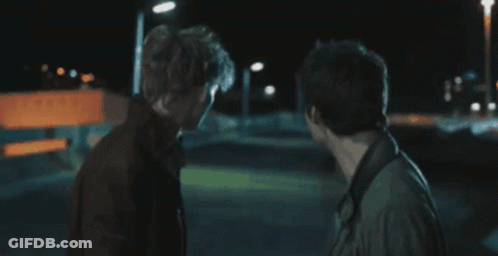 Two Men Standing In Dark Room GIF