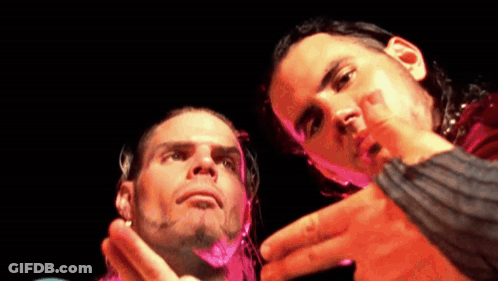 Two Men Standing In Dark Room Looking At Each Other GIF