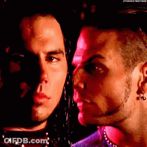 Two Men Standing In Dark Room Looking At Each Other GIF