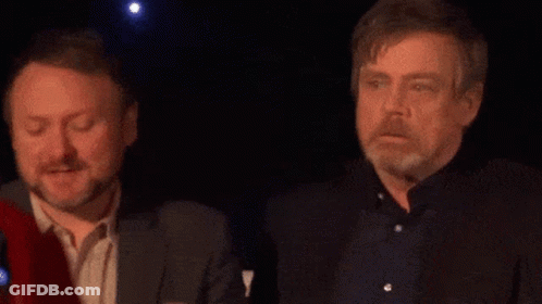 Two Men Standing In Dark Room Looking At Something GIF