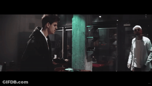 Two Men Standing In Dark Room GIF