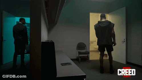 Two Men Standing In Dark Room GIF