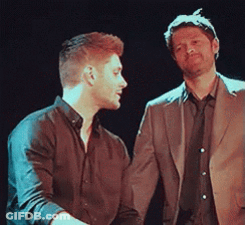 Two Men Standing In Dark Room GIF