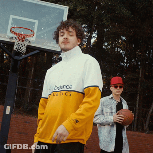 Two Men Standing In Front Of A Basketball Hoop Wearing New Balance Athletics Shirts GIF