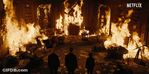 Two Men Standing In Front Of A Burning Room With A Netflix Logo GIF