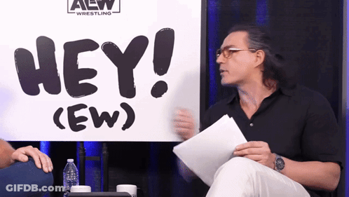Two Men Standing In Front Of AEW Sign GIF