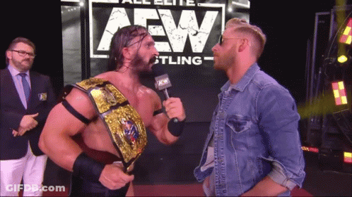 Two Men Standing In Front Of AEW Sign GIF
