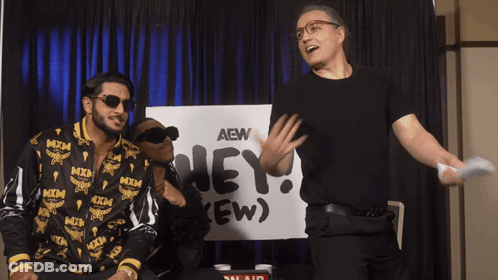 Two Men Standing In Front Of AEW Sign GIF