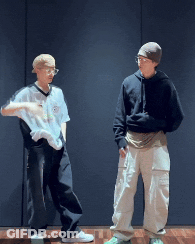 Two Men Standing In Front Of Black Wall GIF