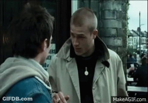 Two Men Standing In Front Of Building GIF