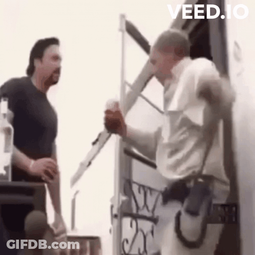 Two Men Standing In Front Of Building GIF