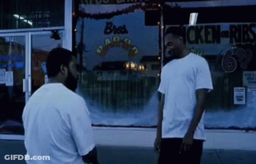 Two Men Standing In Front Of Chicken-Kids Store GIF