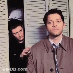 Two Men Standing In Front Of Closet GIF