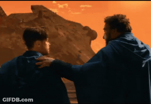 Two Men Standing In Front Of Desert Mountain GIF