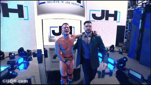 Two Men Standing In Front Of JH Sign GIF
