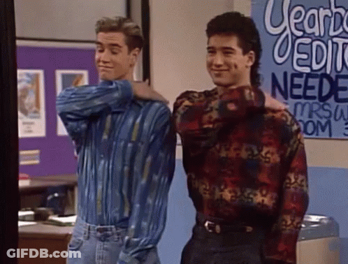 Two Men Standing In Front Of Learn Needs Sign GIF