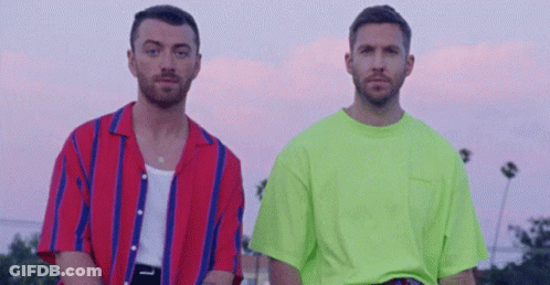 Two Men Standing In Front Of Palm Trees GIF