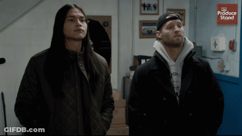 Two Men Standing In Front Of Produce Store GIF