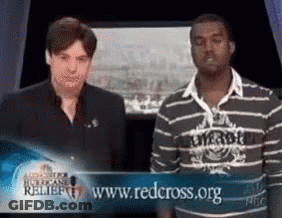 Two Men Standing In Front Of Red Cross Sign GIF