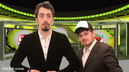 Two Men Standing In Front Of Screen With Cherry GIF