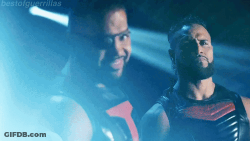 Two Men Standing In Front Of Talla Tonga Sign GIF