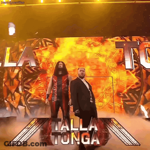 Two Men Standing In Front Of Talla Tonga Sign GIF