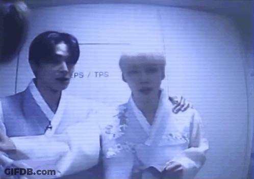 Two Men Standing In Front Of TPS Wall GIF