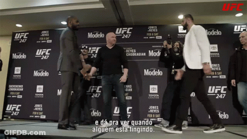 Two Men Standing In Front Of UFC Sign GIF