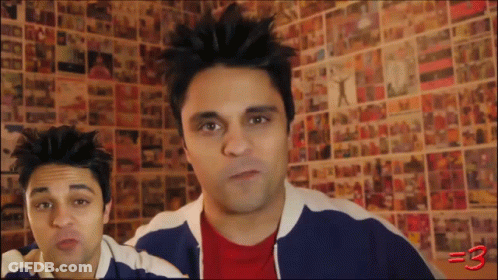 Two Men Standing In Front Of Wall With Pictures Number 3 GIF