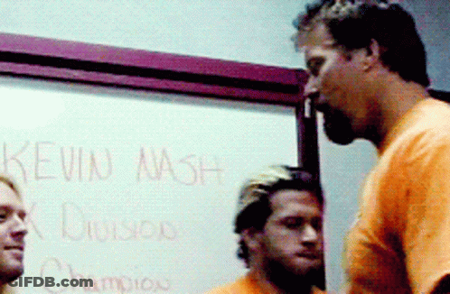 Two Men Standing In Front Of White Board Saying Kevin Nash GIF