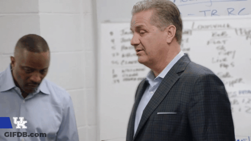 Two Men Standing In Front Of Whiteboard With UK Logo GIF