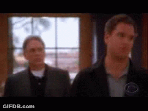 Two Men Standing In Front Of Window GIF