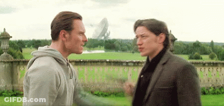 Two Men Standing In Grassy Field GIF