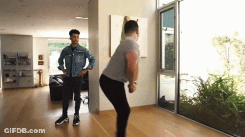 Two Men Standing In Living Room With Large Window GIF