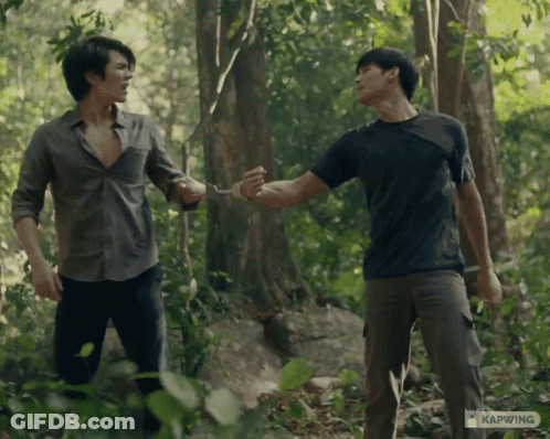 Two Men Standing In The Woods With Kapwing Written On The Bottom Left GIF