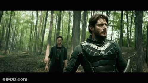 Two Men Standing In Woods Looking GIF