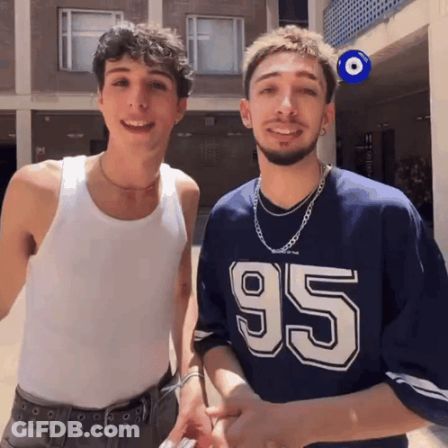 Two Men Standing Next To Each Other GIF
