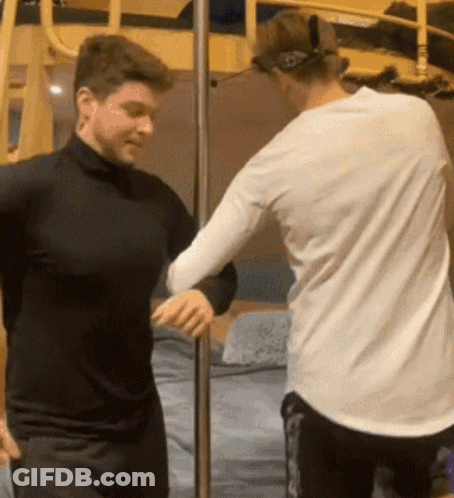 Two Men Standing Next To Each Other GIF