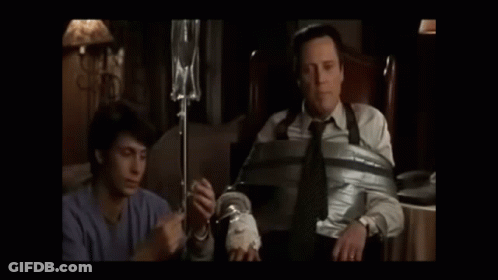 Two Men Standing Next To Each Other In A Dark Room GIF