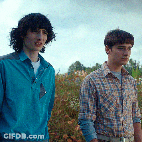 Two Men Standing Next To Each Other In A Field GIF
