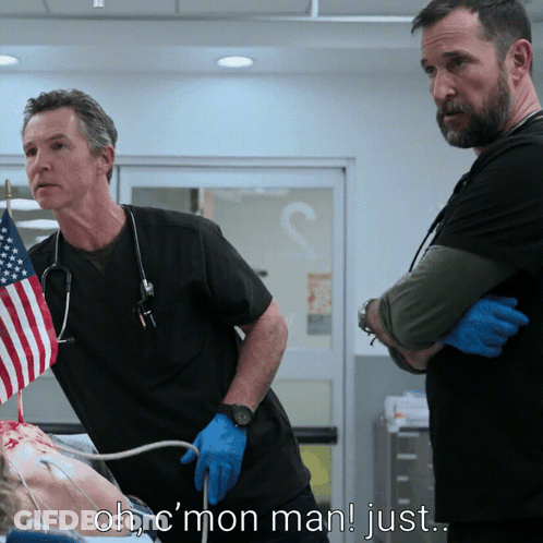 Two Men Standing Next To Each Other In A Hospital Room With The Words Ohc Mon Man Just Above Them GIF